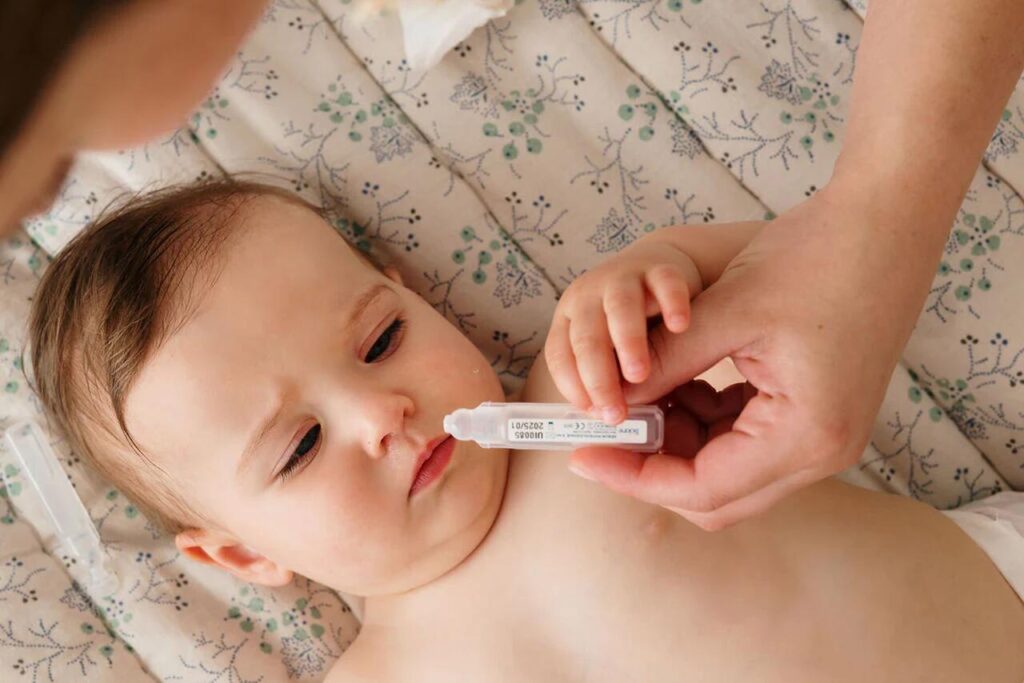 Bebe deitado vai fazer lavagem nasal.