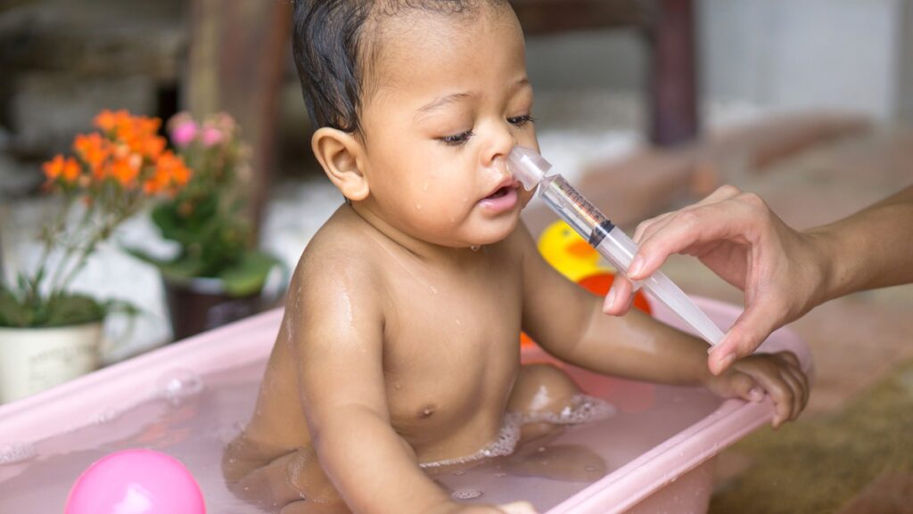 Bebe fazendo lavagem nasal.